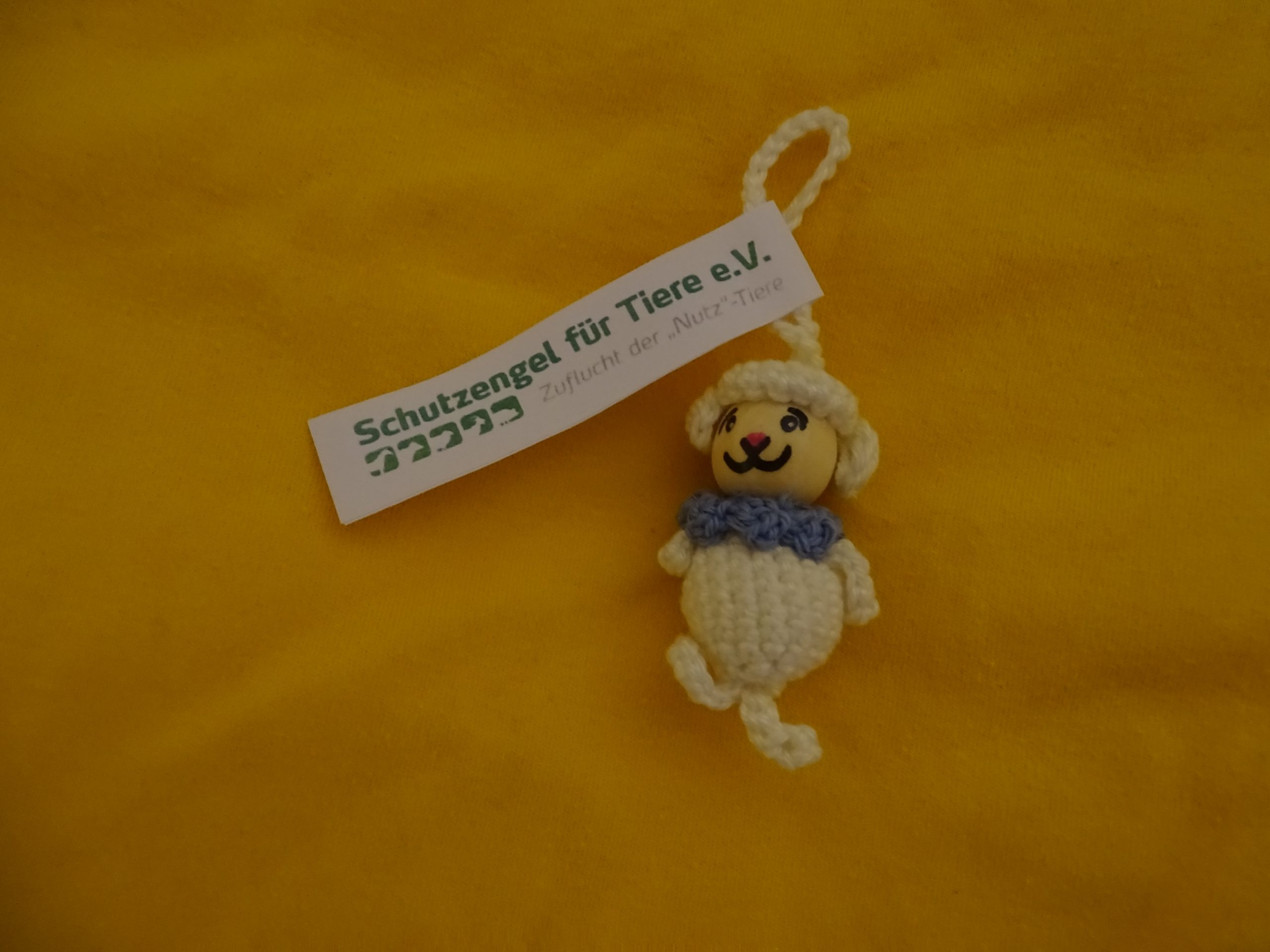 Schaf-Glückswürmchen aus veganer "Wolle" mit Füßen und blauem Halstuch