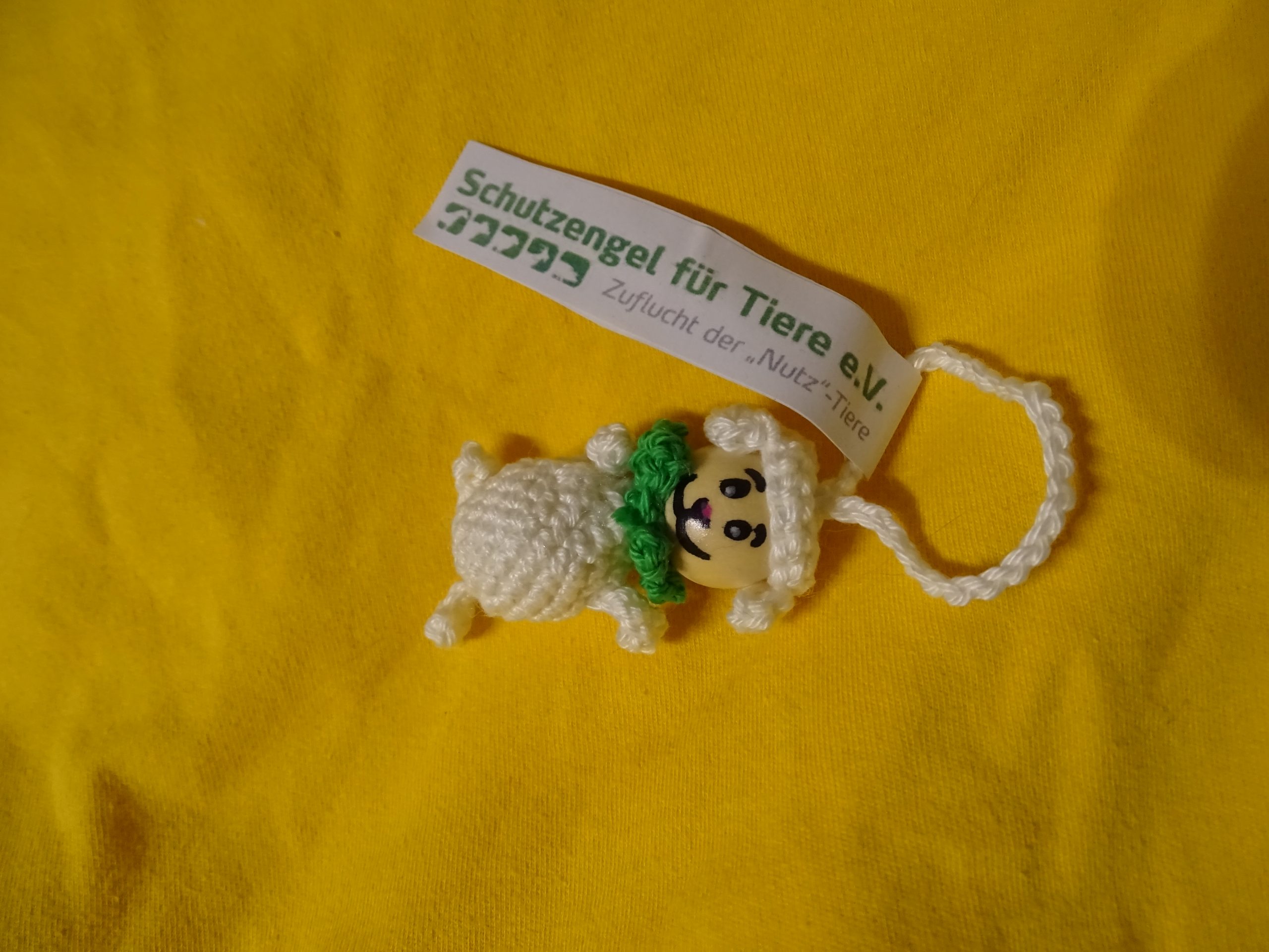 Schaf-Glückswürmchen aus veganer "Wolle" mit Füßen und grünem Halstuch